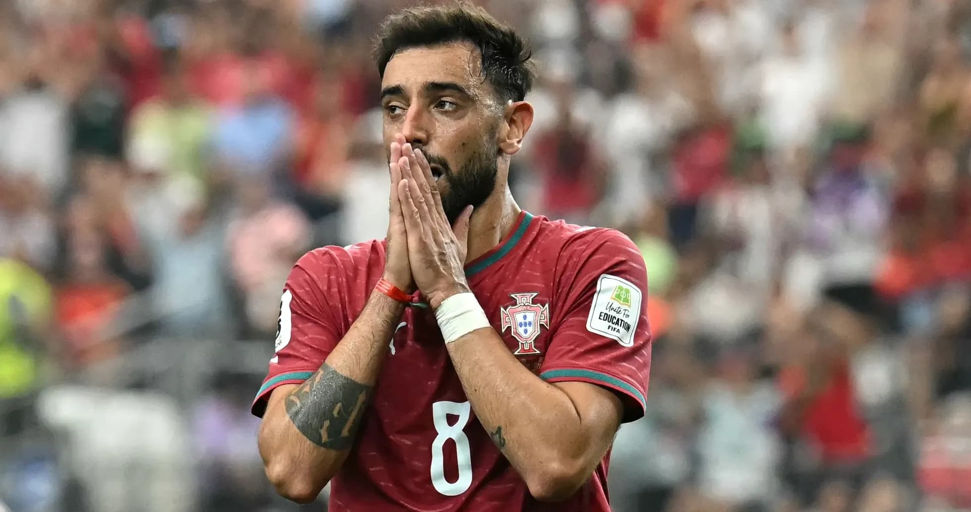 Jugador de Portugal con manos en el rostro durante partido