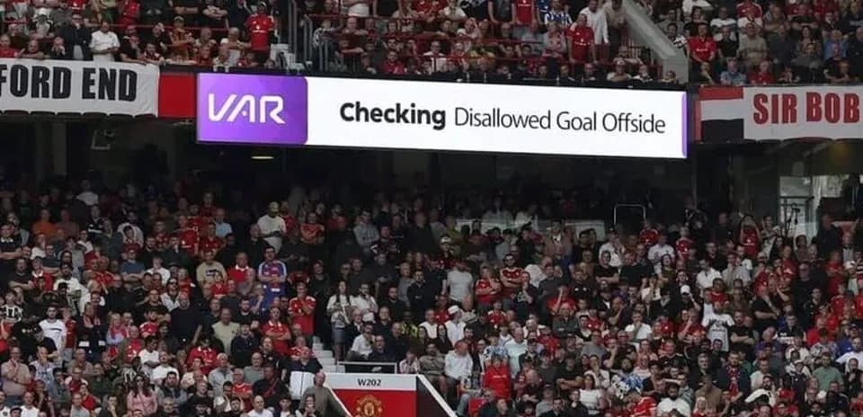 A crowd watching VAR decision about disallowed goal