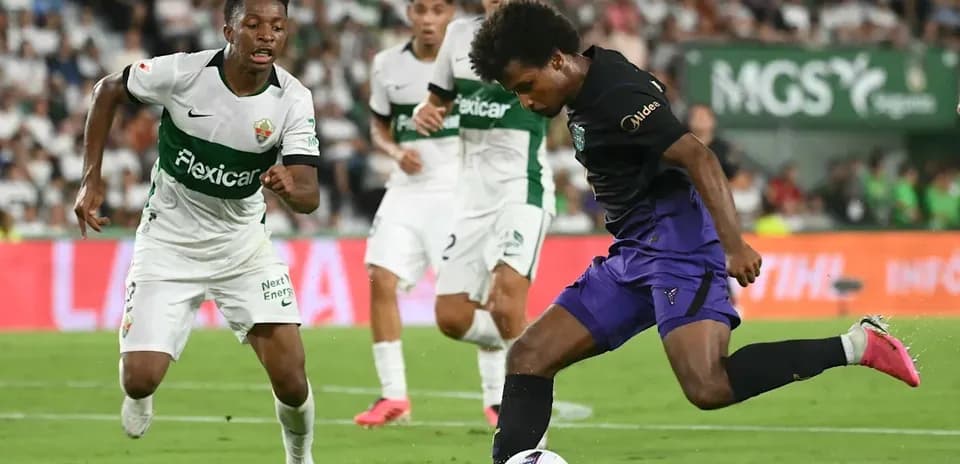 Jugador de Elche persiguiendo a rival con balón