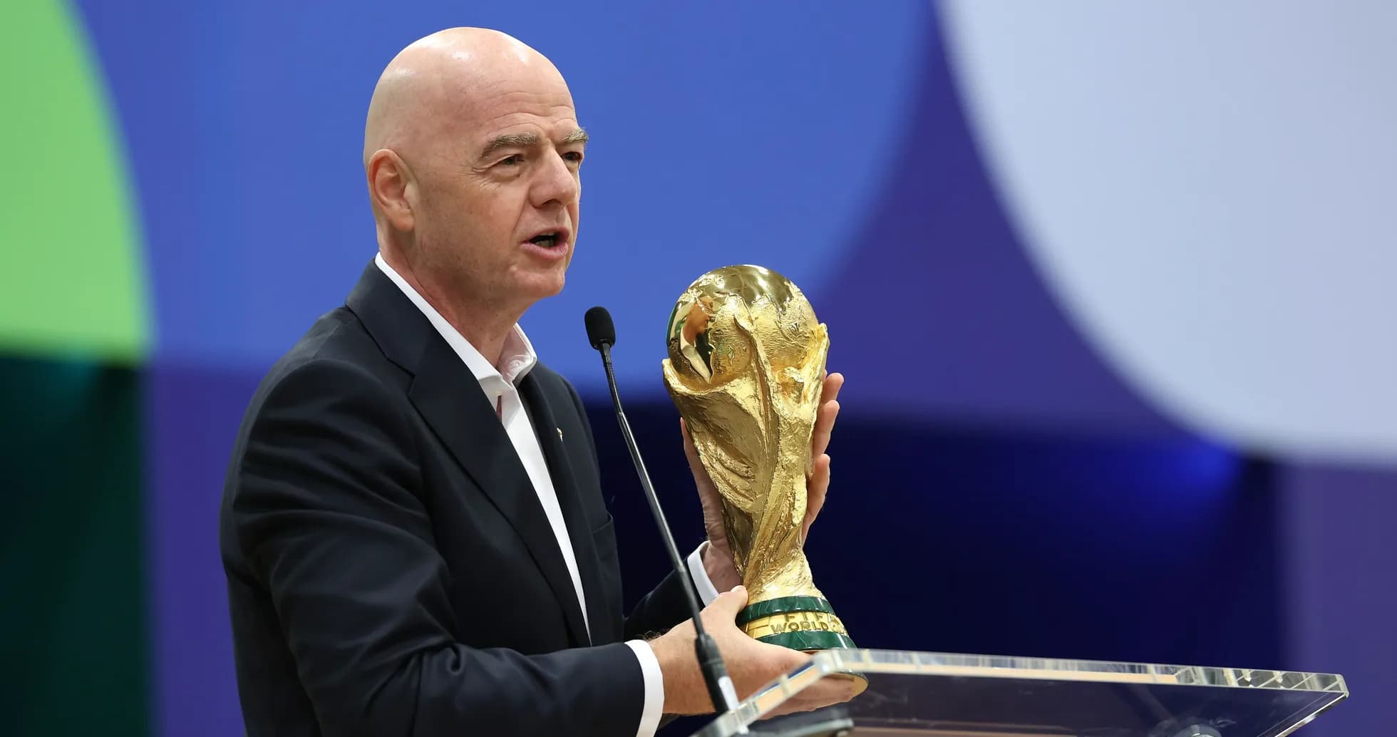 Funcionario sosteniendo la Copa del Mundo en el podio
