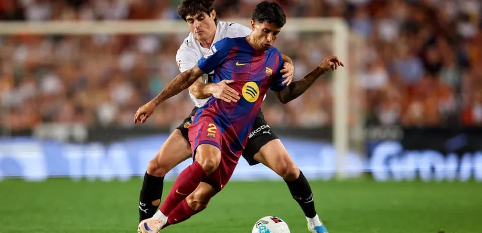 Jugador de Barcelona luchando por el balón contra rival
