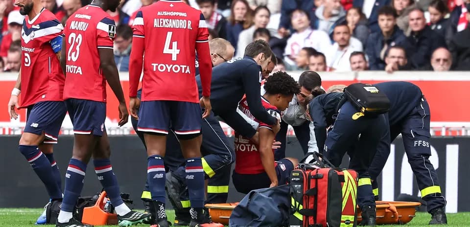 Jugadores de Lille rodeando a un compañero lesionado