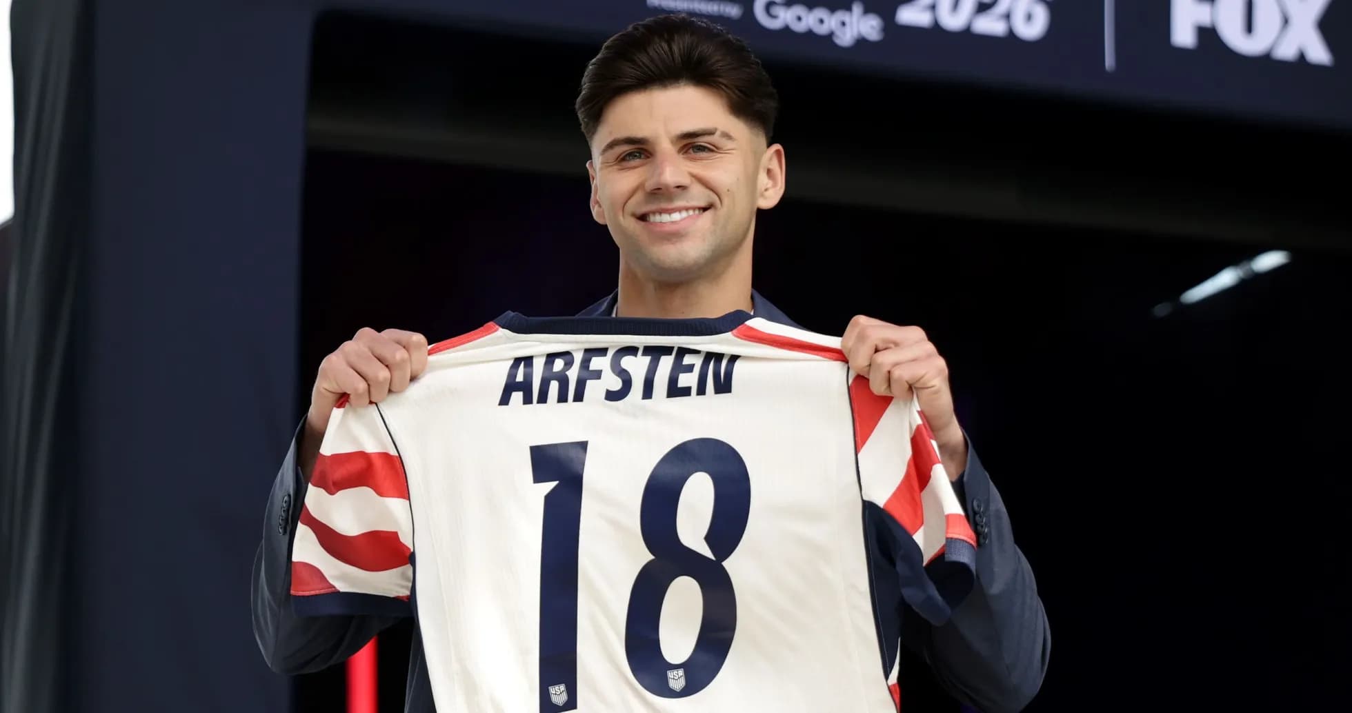 Jugador sostiene camiseta con el nombre ARFSTEN y número 18