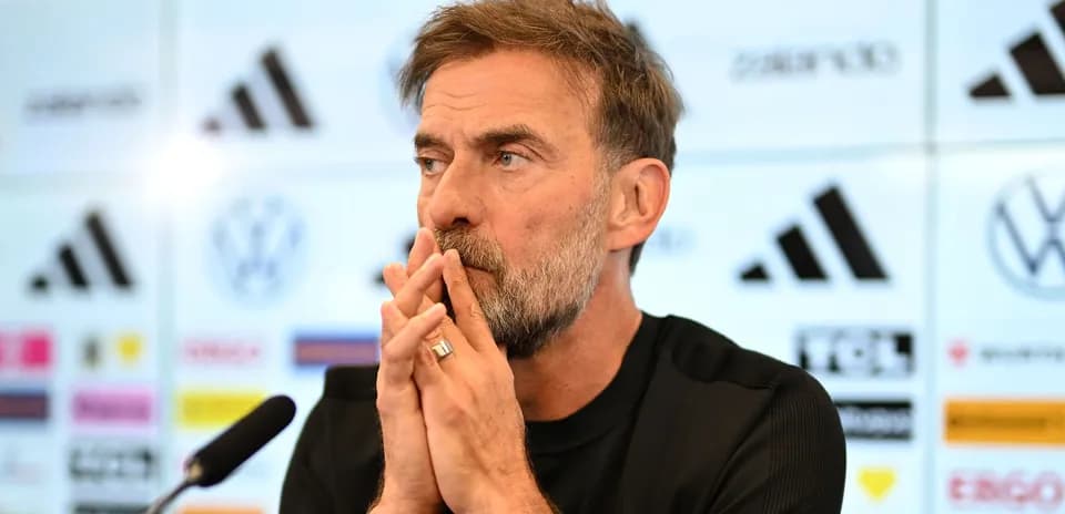 Entrenador en conferencia de prensa, manos en rostro