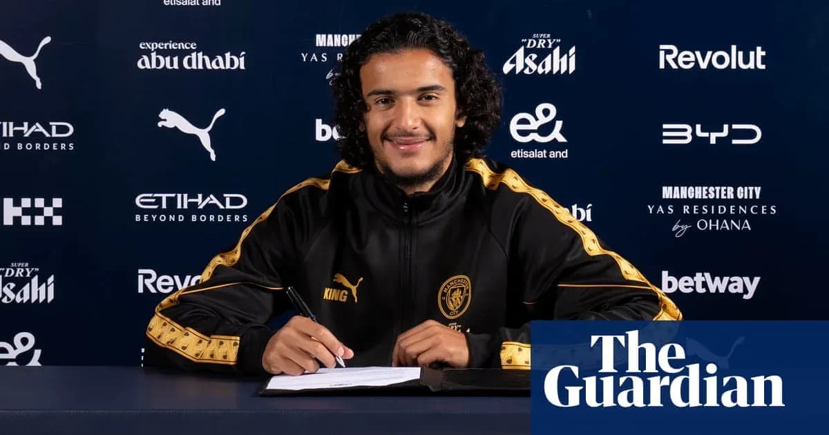 Jugador firmando contrato en mesa de prensa
