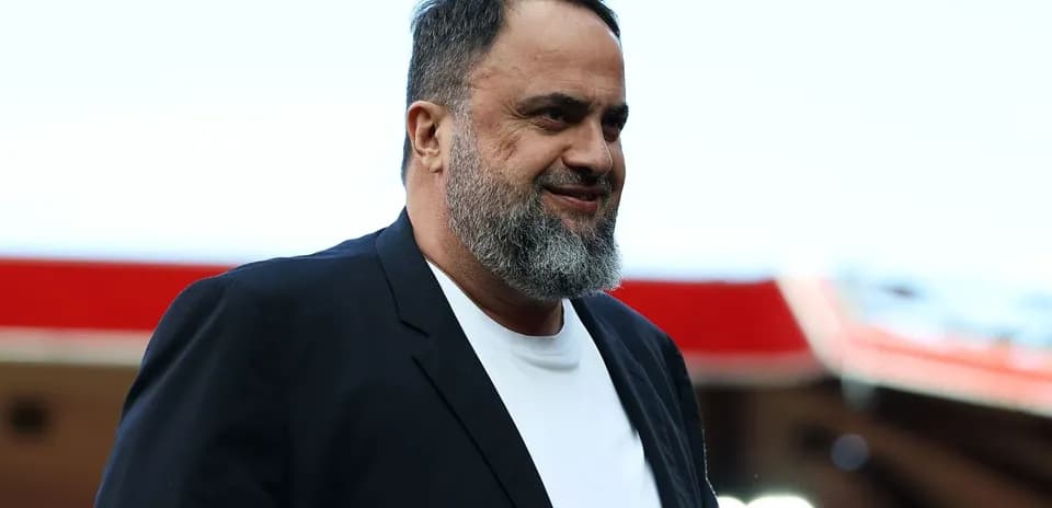 Hombre con barba y chaqueta negra en estadio