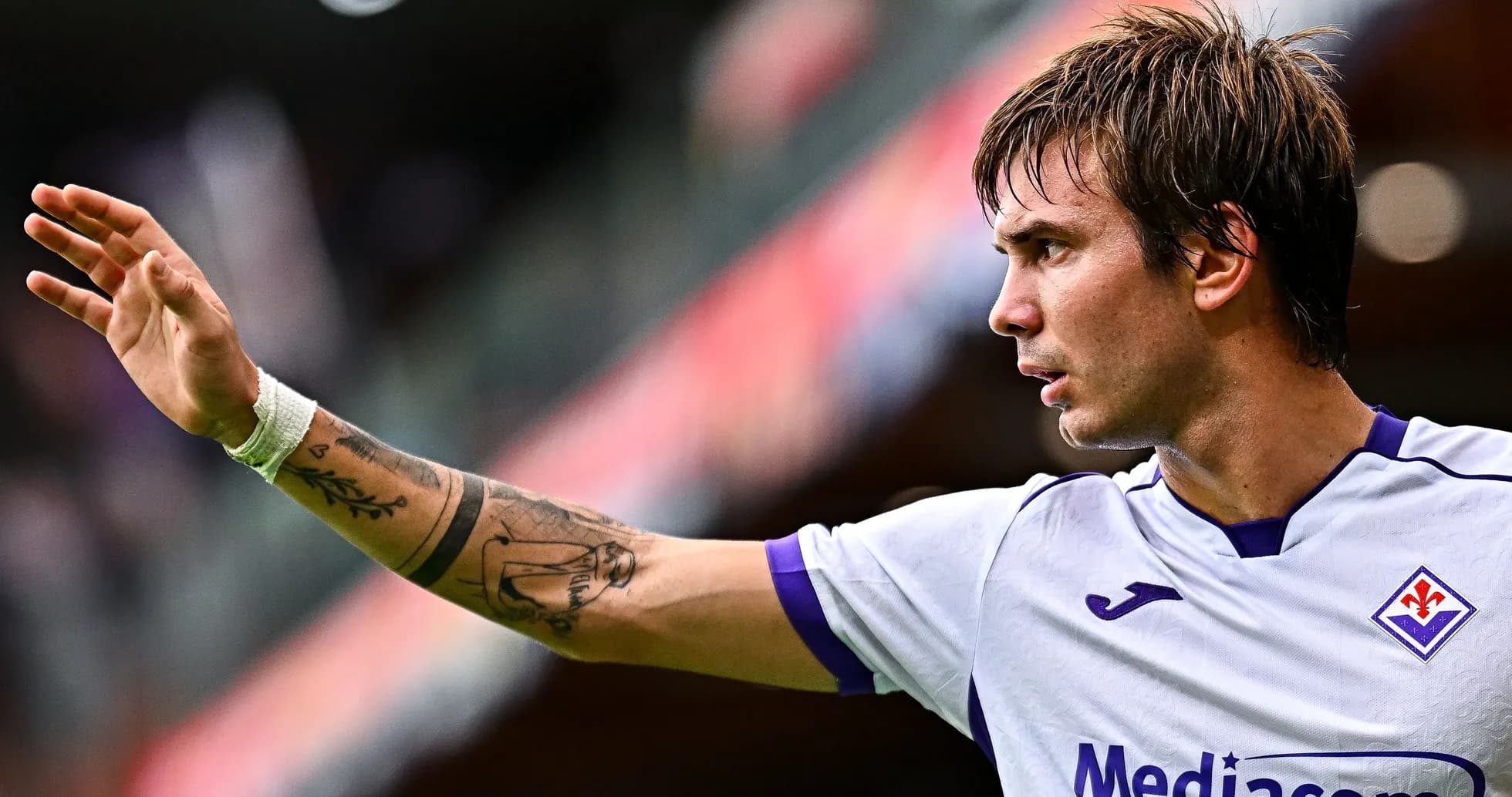Jugador de la Fiorentina levantando la mano durante el partido