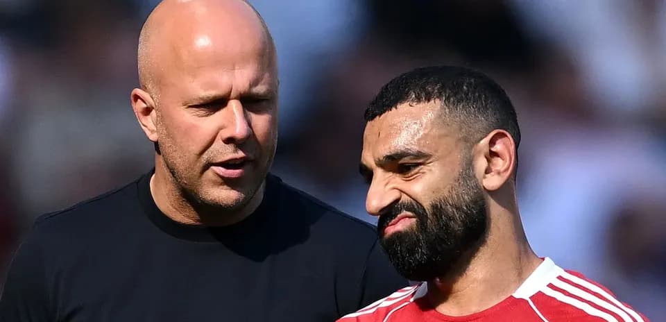 Dos hombres conversando durante un partido de fútbol