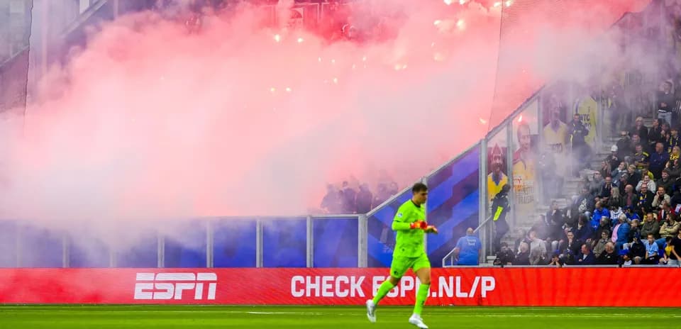 Portero caminando mientras hay humo en el estadio