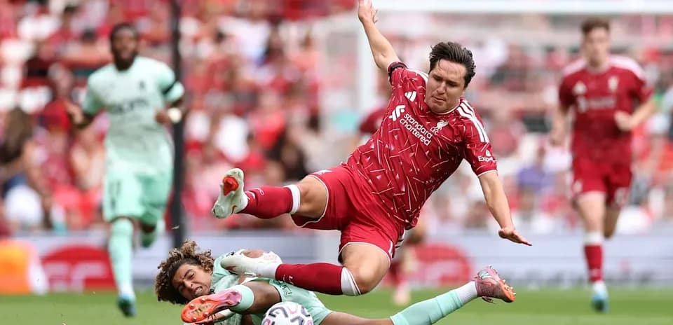 Jugador de Liverpool cae tras una falta en el partido