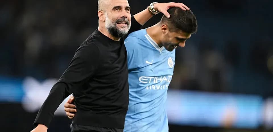 Entrenador y jugador de Manchester City celebrando juntos