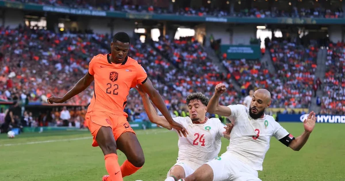 Jugador de Países Bajos driblando entre defensores de Marruecos