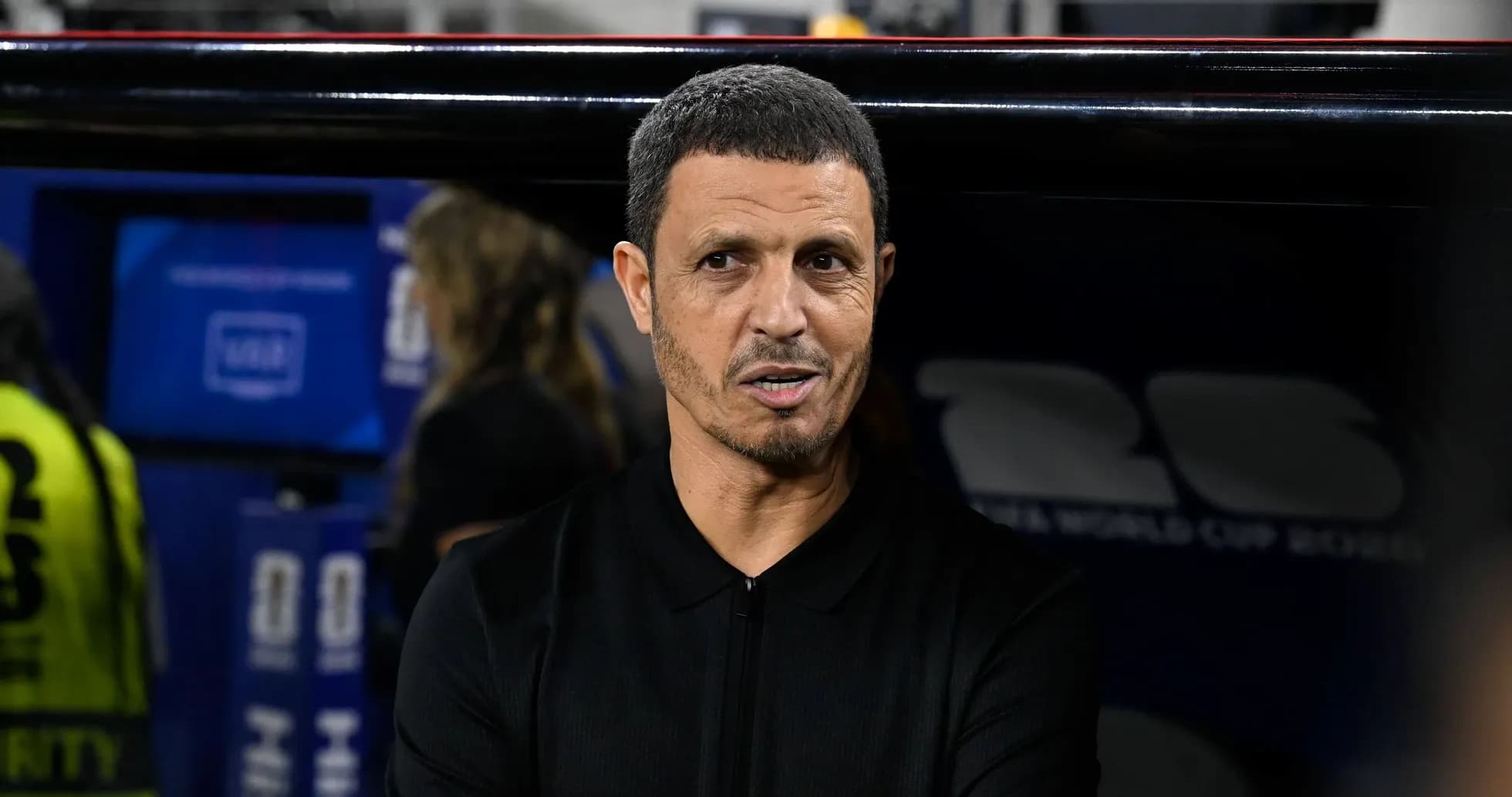 Entrenador en banquillo durante partido de fútbol