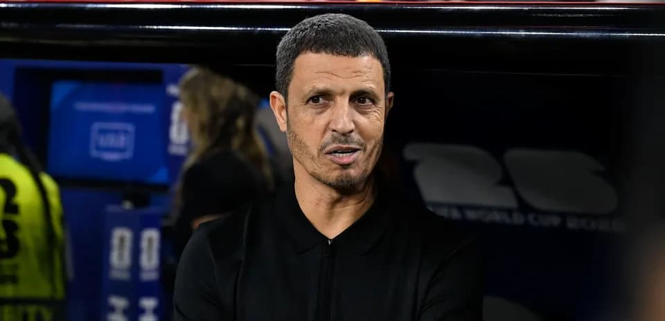 Entrenador en banquillo durante partido de fútbol
