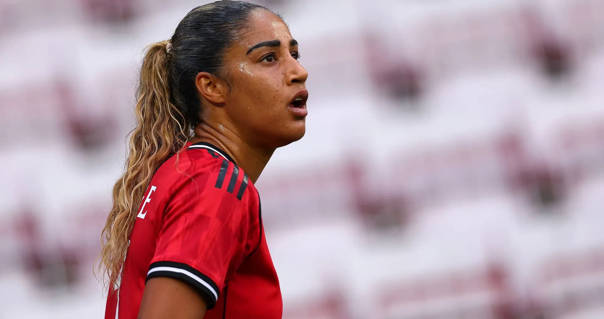 Jugadora de fútbol con camiseta roja en el campo