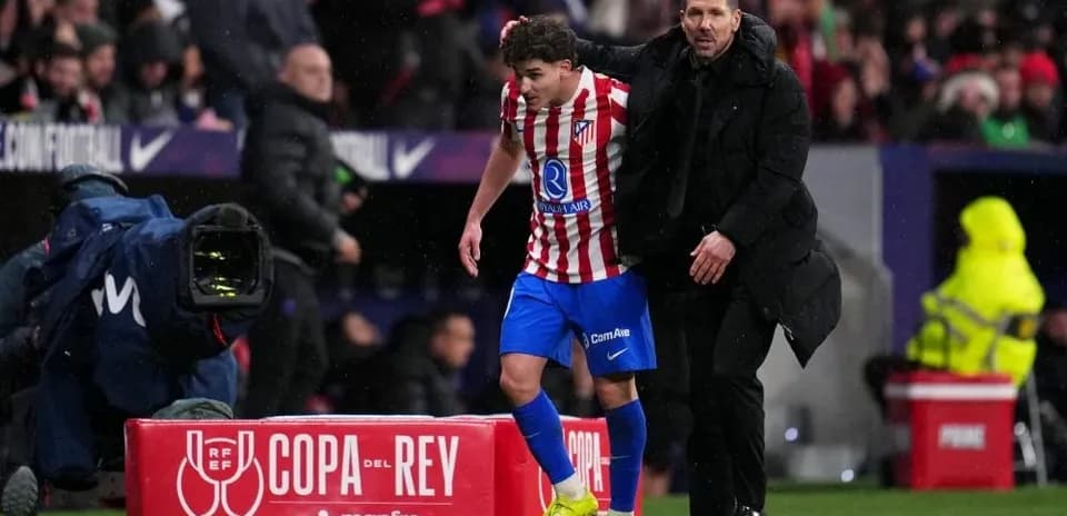 Entrenador ayudando a jugador del Atlético de Madrid