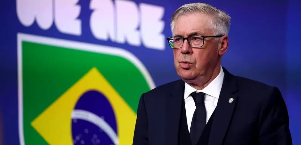 Entrenador hablando frente a la bandera de Brasil