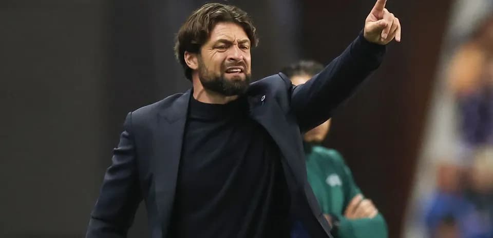 Entrenador dirigiendo a su equipo desde la línea lateral
