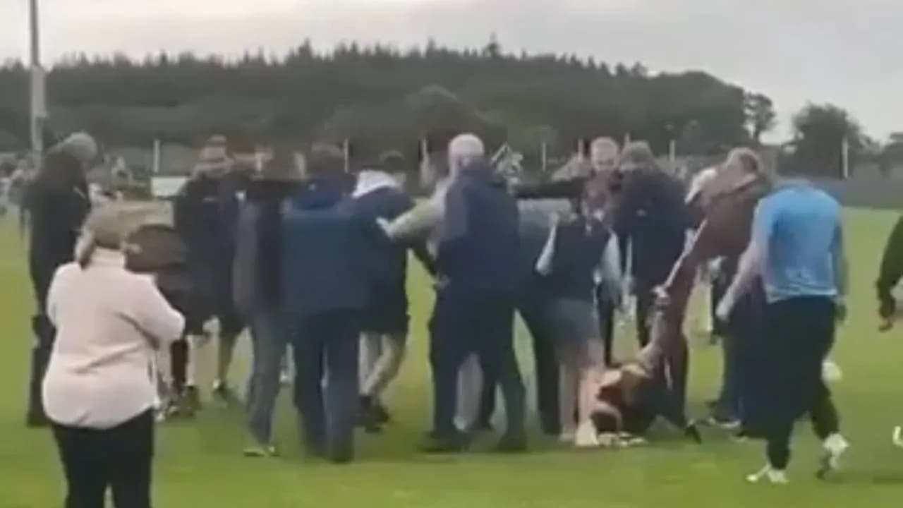 Multitud rodeando a un jugador caído en el campo