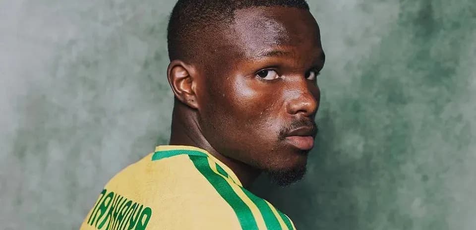 Jugador de fútbol posando con camiseta amarilla