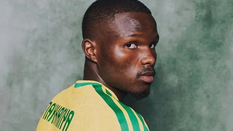 Jugador de fútbol posando con camiseta amarilla
