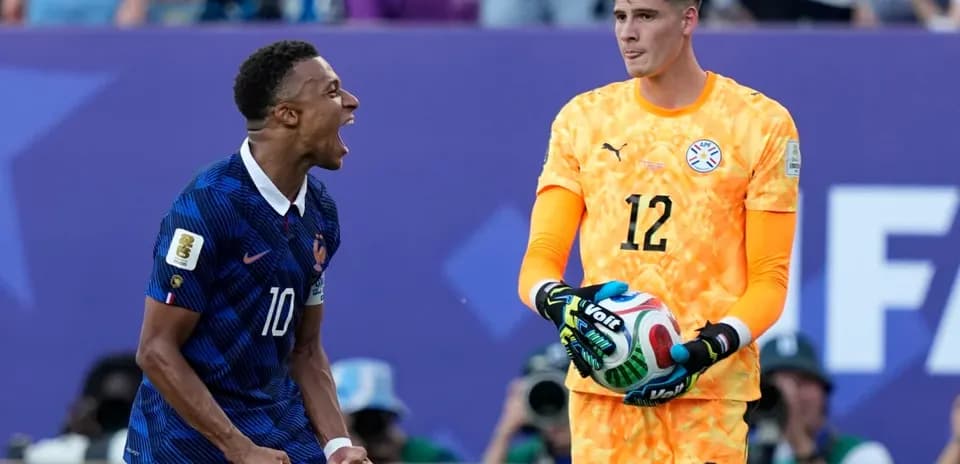 Jugador francés celebrando mientras el portero paraguayo observa