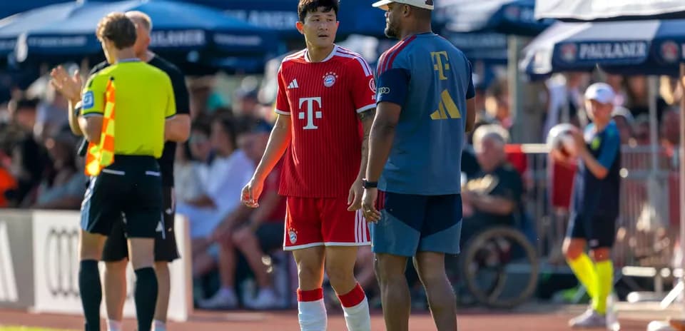 Jugador de Bayern Munich hablando con entrenador en el campo