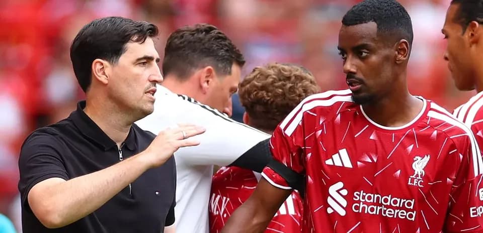 Entrenador hablando con jugador de Liverpool en el campo