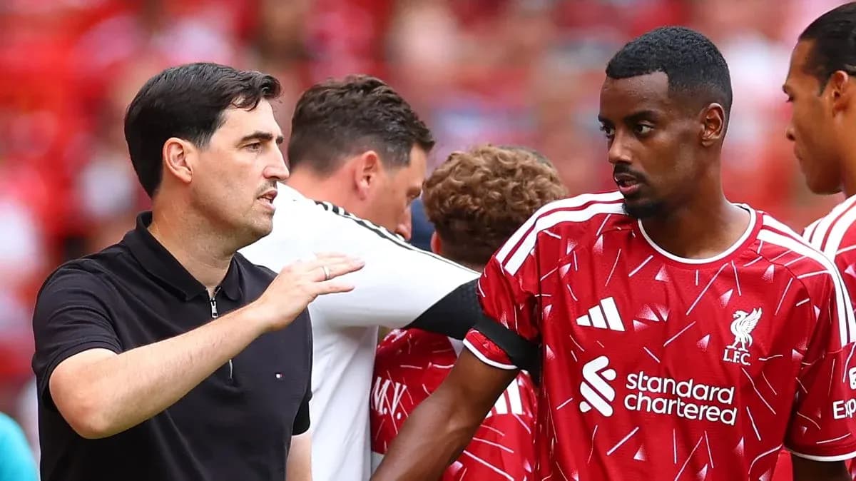 Entrenador hablando con jugador de Liverpool en el campo