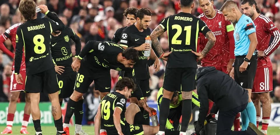 Jugadores de Atlético de Madrid rodeando a compañero lesionado
