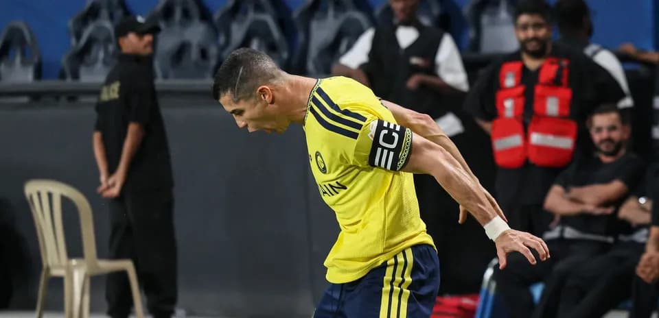 Jugador celebrando con camiseta amarilla en el banquillo
