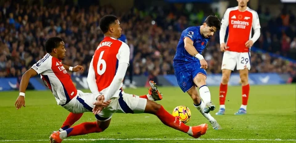 Jugador de Chelsea disparando mientras es defendido