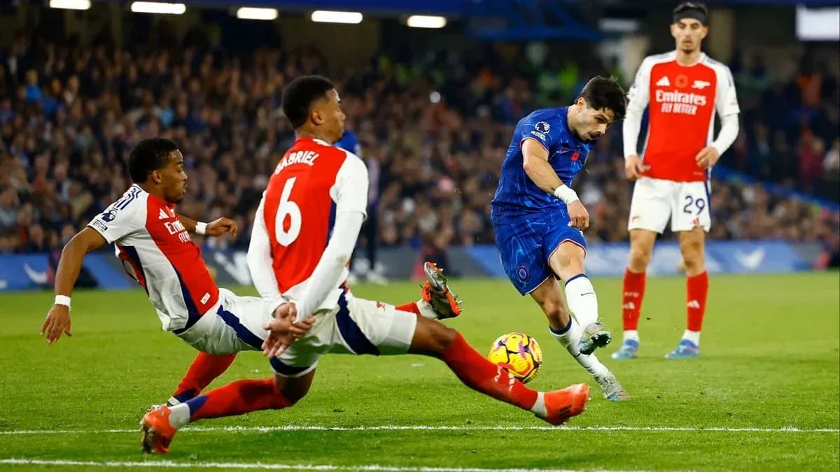 Jugador de Chelsea disparando mientras es defendido