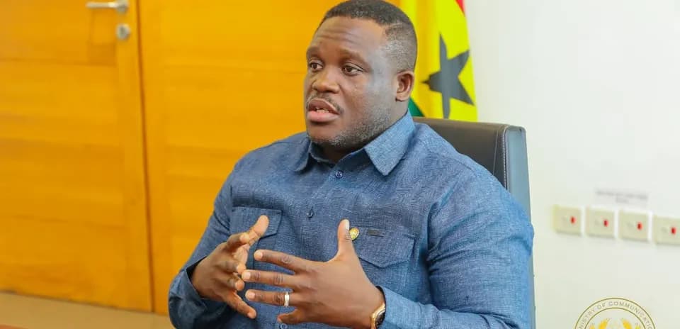 Persona hablando en oficina con bandera de Ghana