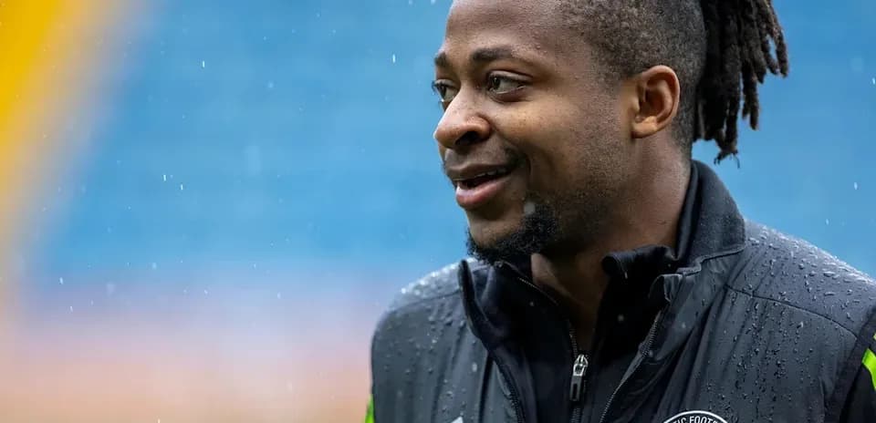 Jugador sonriendo bajo la lluvia en el campo