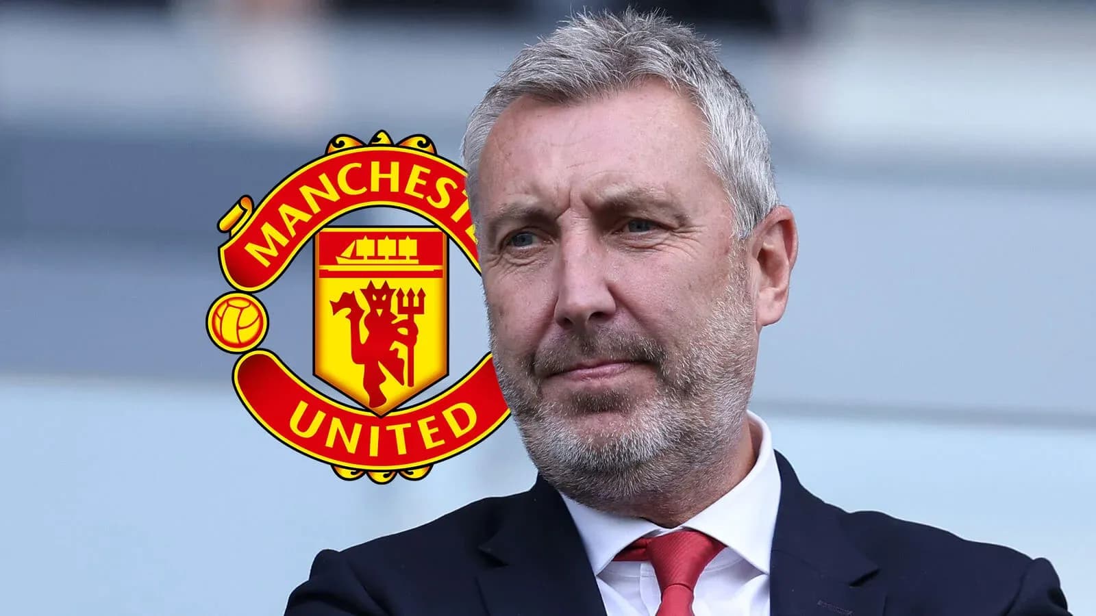 Hombre con traje frente al escudo de Manchester United