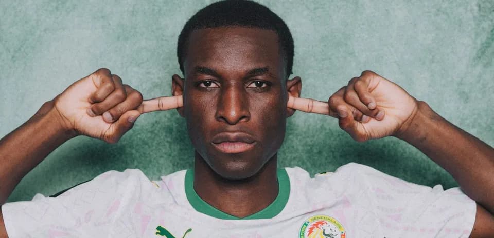 Jugador de Senegal tapándose los oídos con las manos