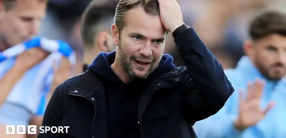 Entrenador tocándose la cabeza durante el partido
