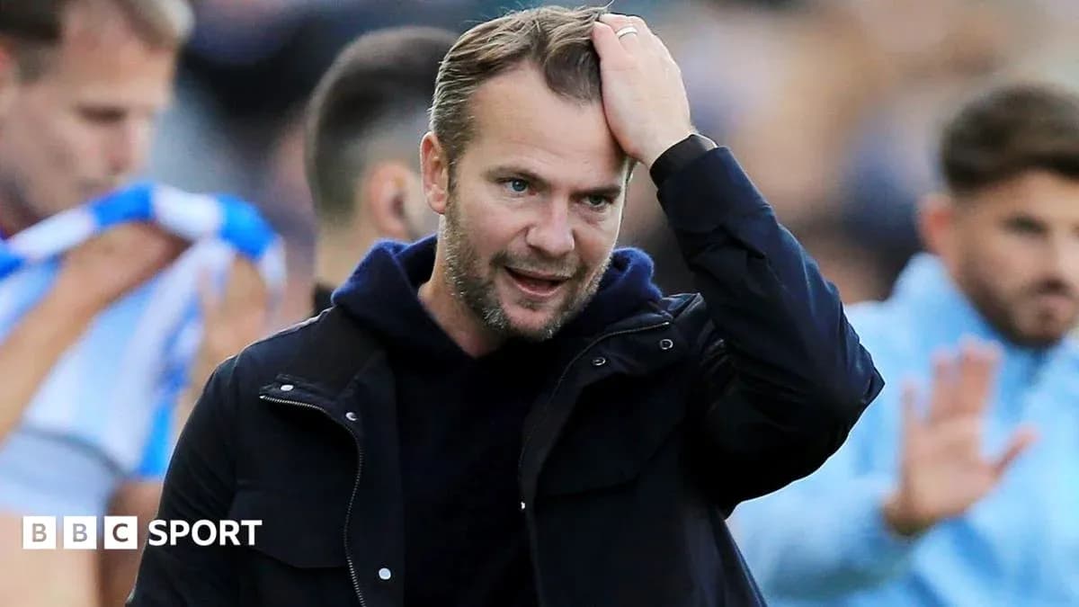 Entrenador tocándose la cabeza durante el partido