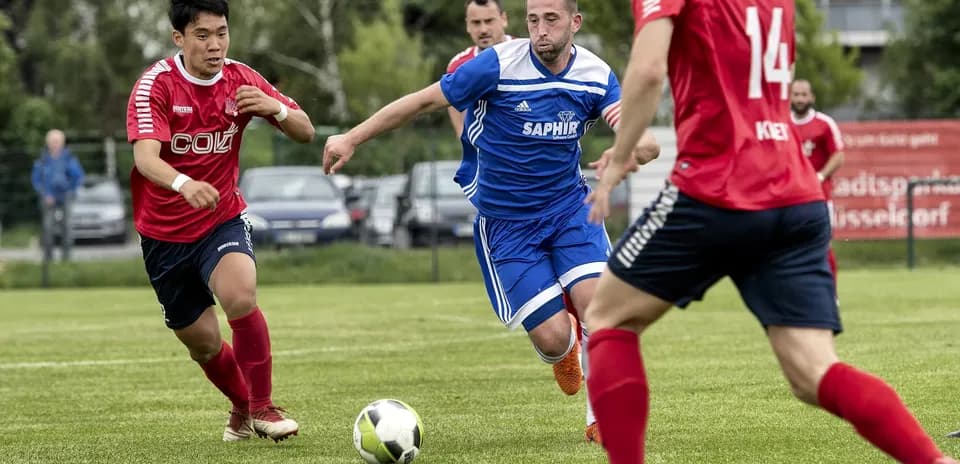 Jugador persigue el balón en partido de fútbol