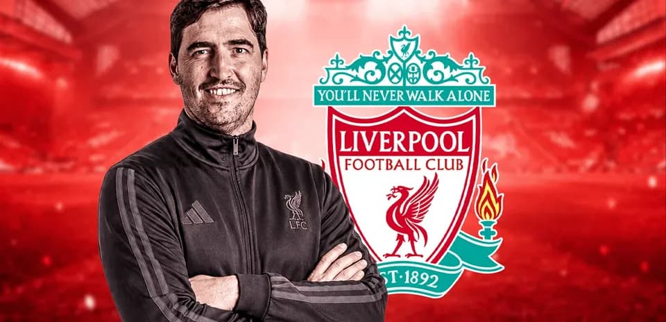 Entrenador posando frente al escudo del Liverpool