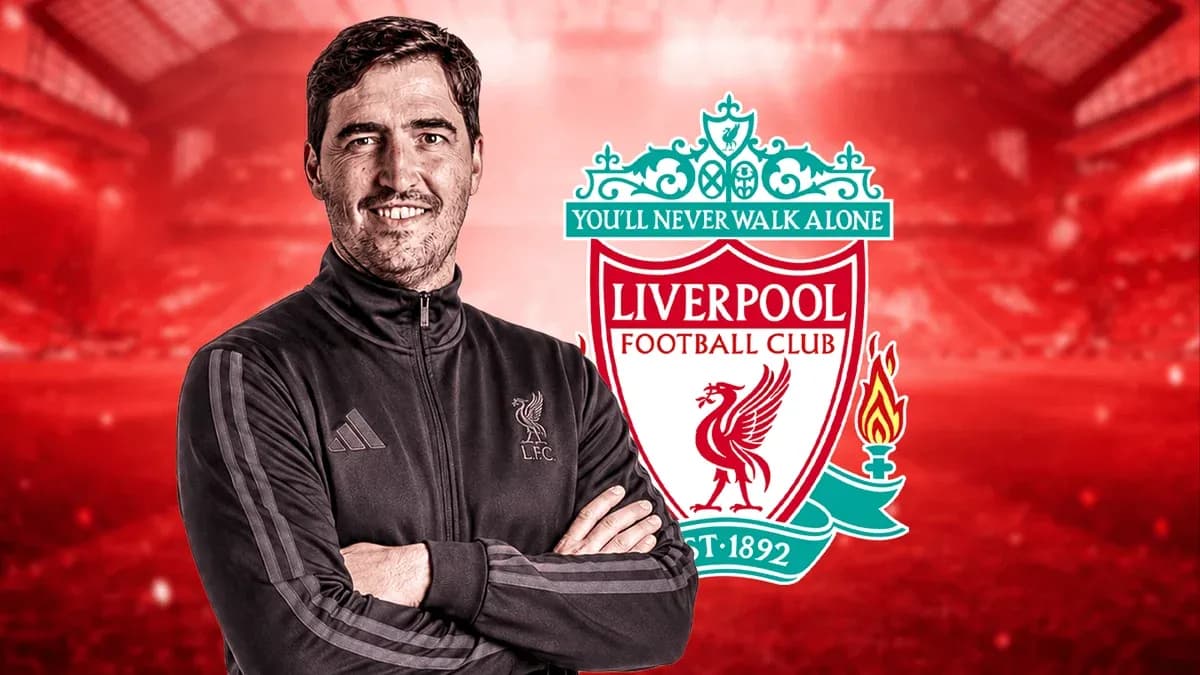 Entrenador posando frente al escudo del Liverpool