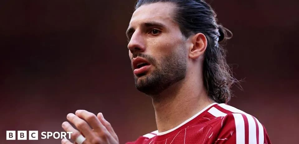 Jugador con camiseta roja aplaudiendo en el campo