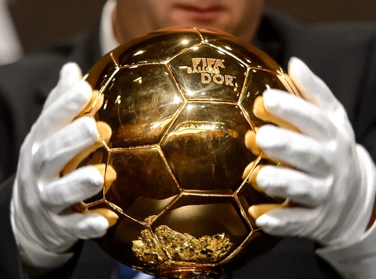 Trofeo Balón de Oro sostenido con guantes blancos