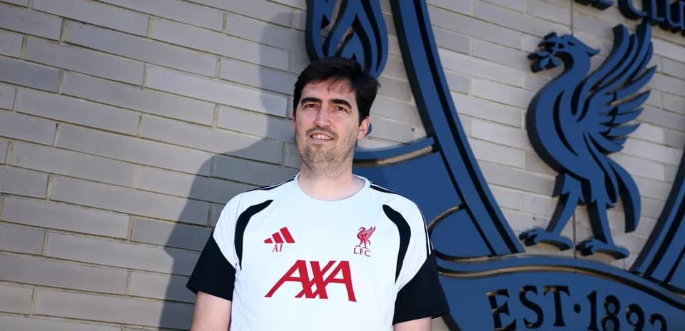 Persona con camiseta de Liverpool frente al club