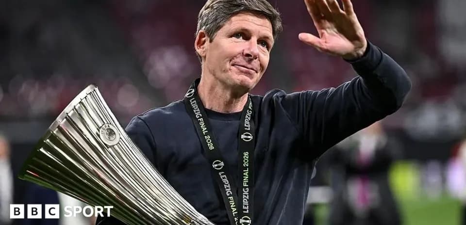 Entrenador levantando trofeo y saludando al público