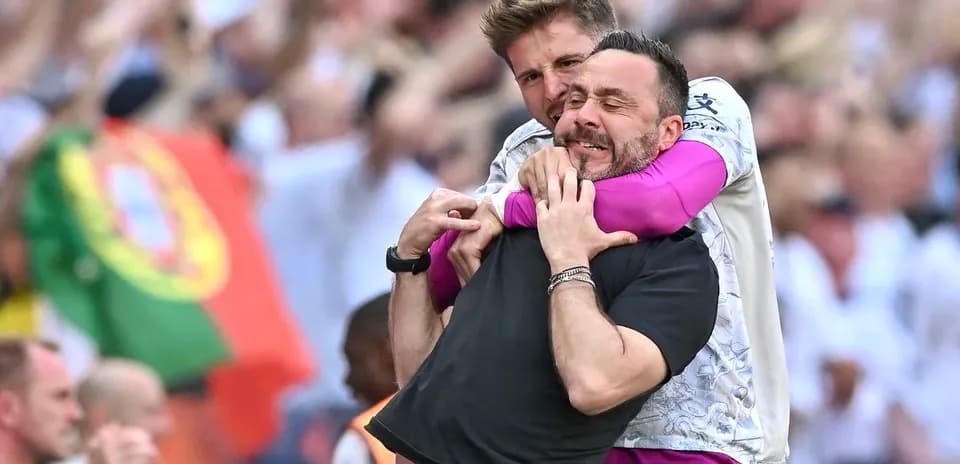 Entrenadores celebrando en el campo durante el partido