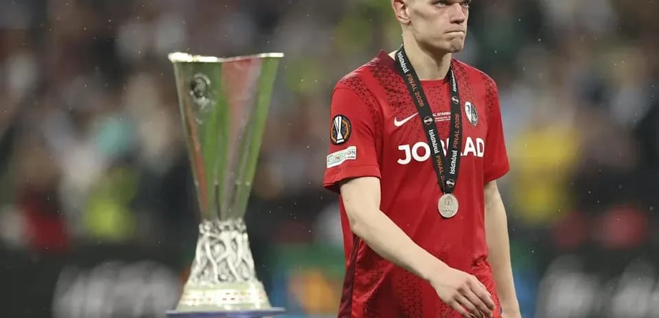 Jugador con medalla caminando junto al trofeo
