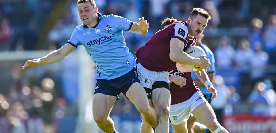 Jugador de Galway avanzando con el balón mientras es tackleado