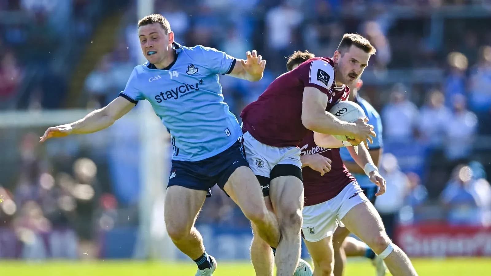 Jugador de Galway avanzando con el balón mientras es tackleado